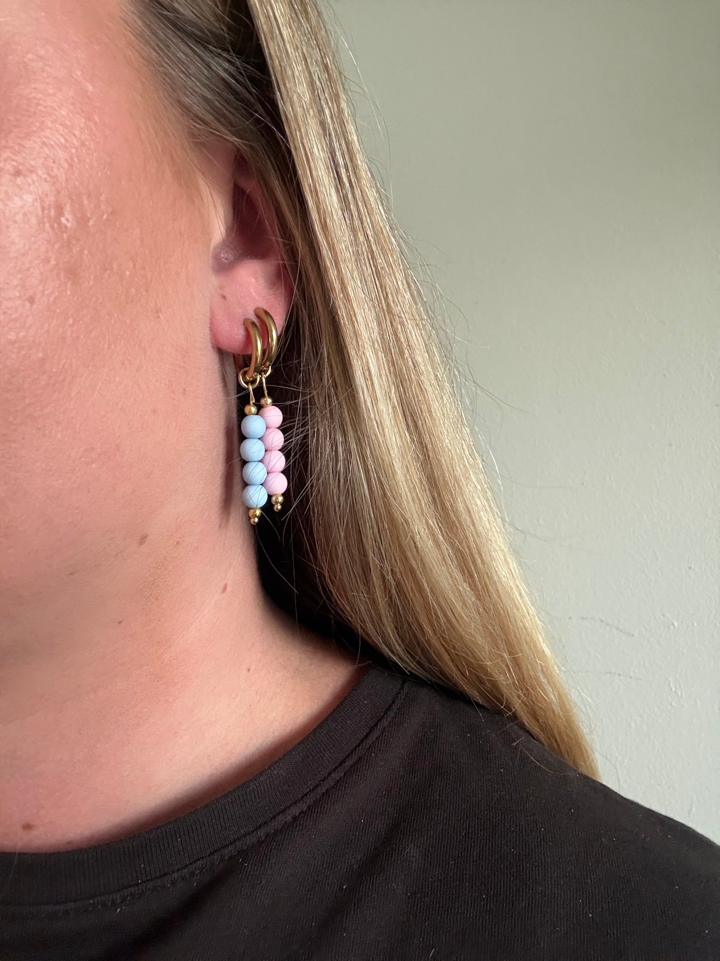 Britt hoops zijn gouden oorbellen met roze kralen