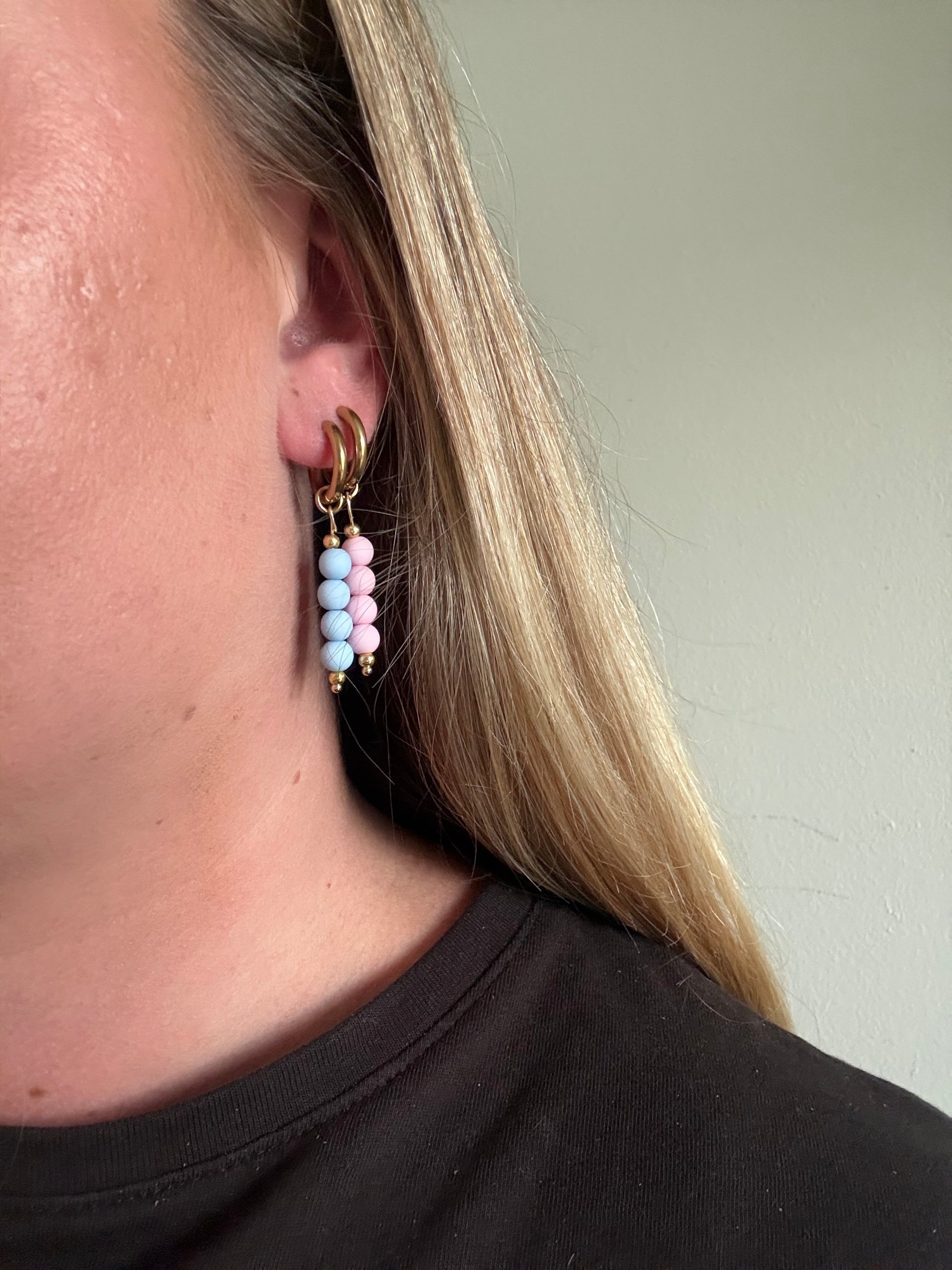 Britt hoops zijn gouden oorbellen met roze kralen