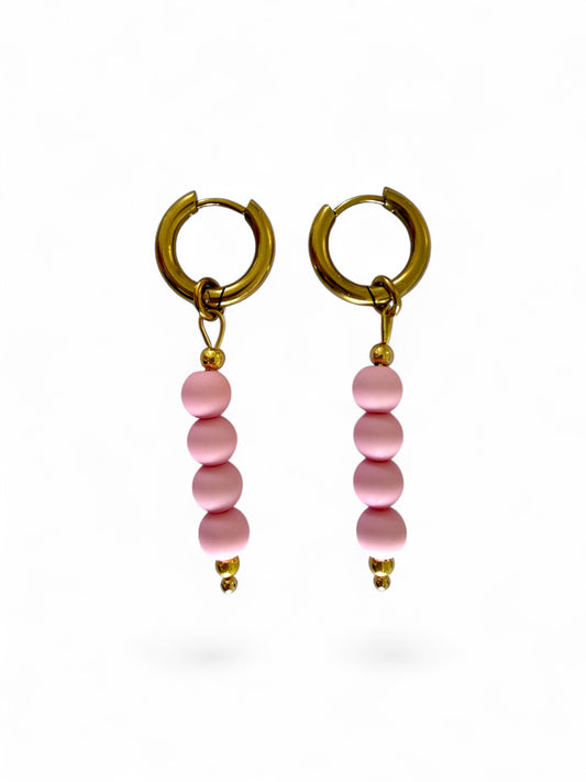 Britt hoops zijn gouden oorbellen met roze kralen