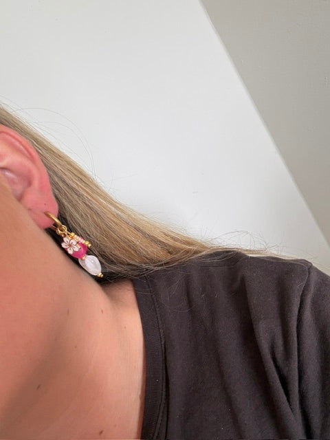Fleur oorbellen goud stainless steel met wit en roze hart. een wit bloemenbedeltje met roze kralen
