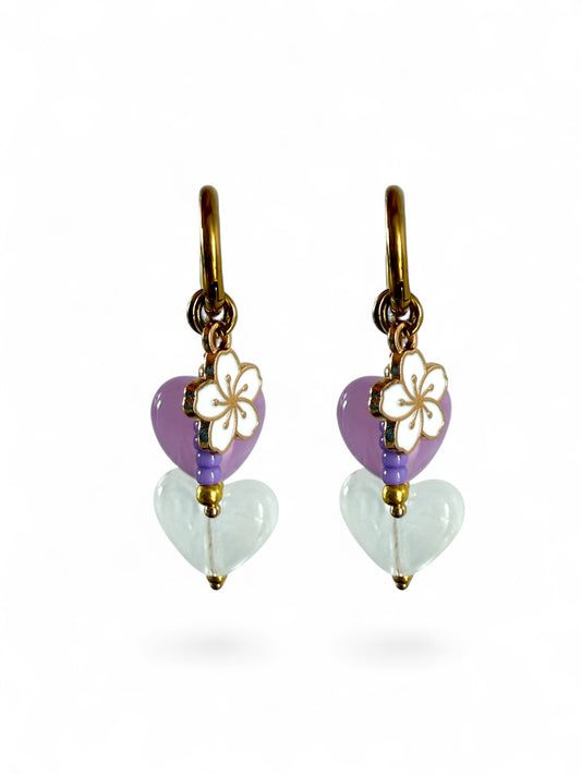De lavender oorbellen zijn gouden stainless steel oorbellen met een wit en paars hartje, een wit bloemen bedeltje en paarse kralen 