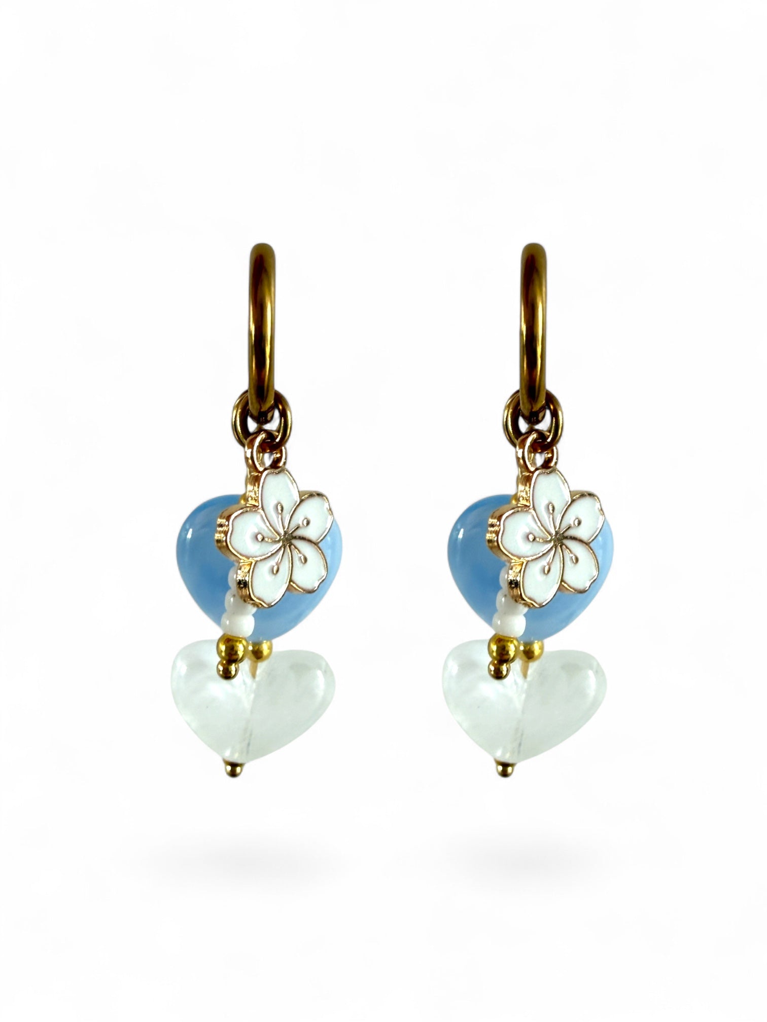 Mist oorbellen stainless steel met een blauw en wit hartje. Wit bloemenbedeltje en witte kralen