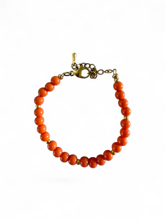 De Sandie armband is stainless steel en handgemaakt met oranje kralen.