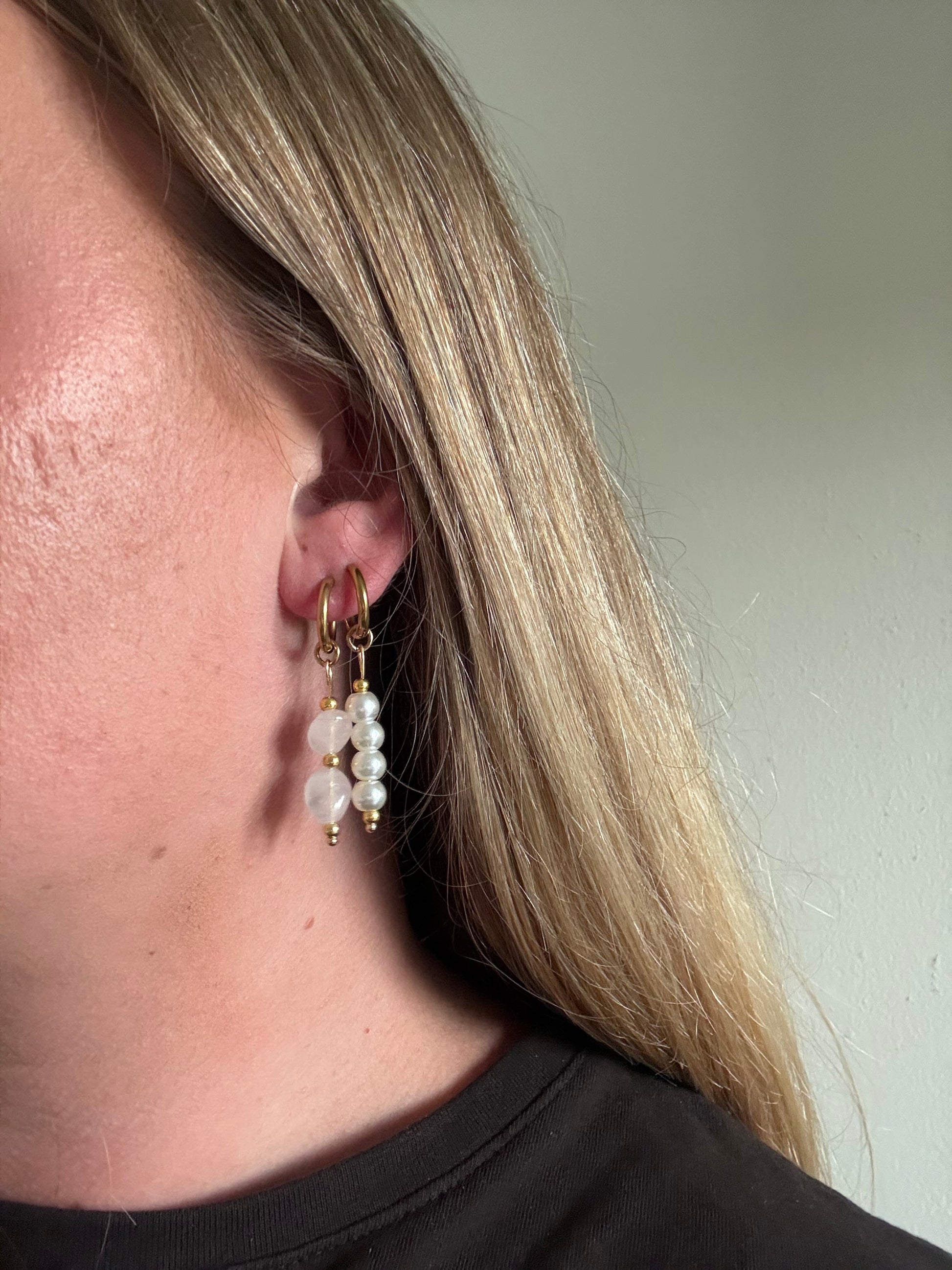 Elara Hoops gouden stainless steel oorbellen met roze natuursteen gedragen door model